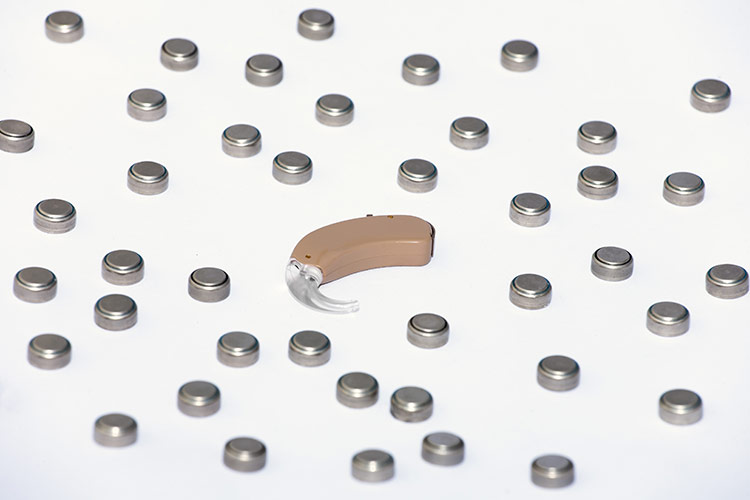 hearing aid surrounded by batteries